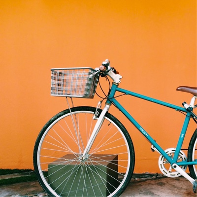 teal bicycle against a orange wall